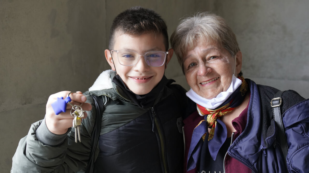 abuelita y nieto con llaves en las manos de su vivienda