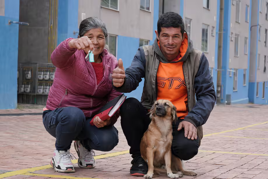 familia con mascota mostrando sus llaves de su nueva vivienda vis
