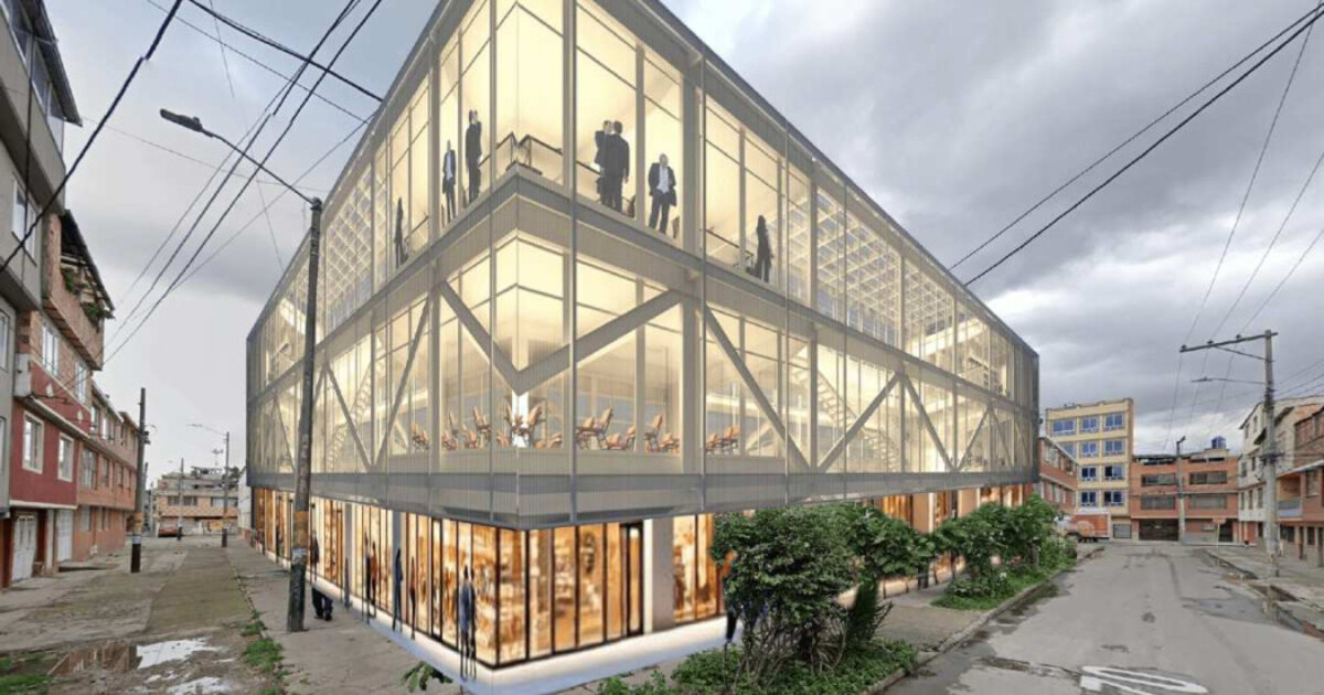 Edificio moderno de vidrio en una esquina, con personas visibles en el interior, rodeado por viviendas, postes y cables eléctricos.